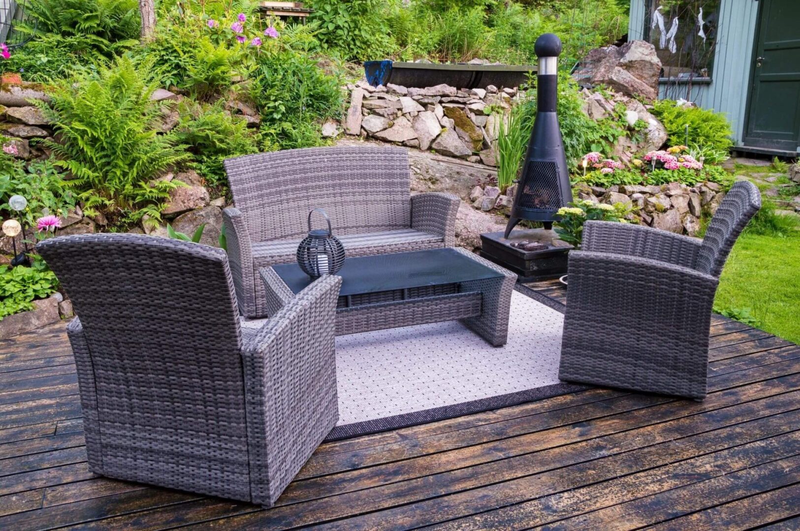 A patio set with a cat sitting on the back of it.