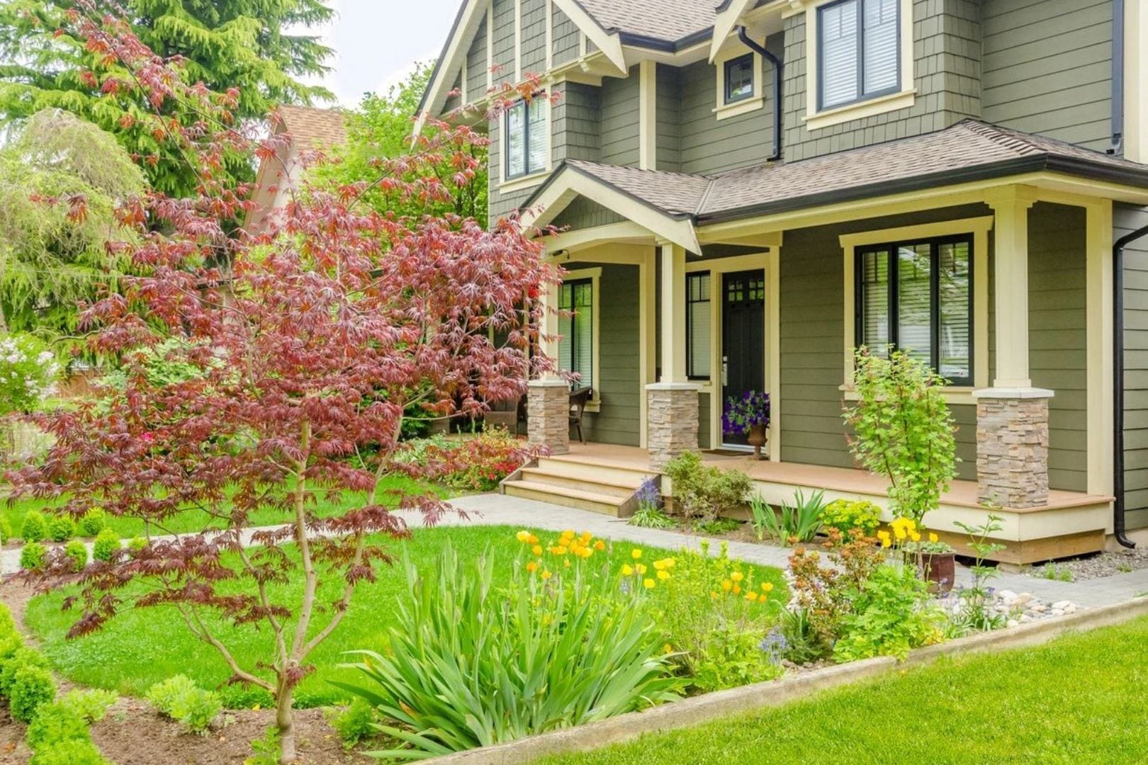 A house with flowers in the front yard.