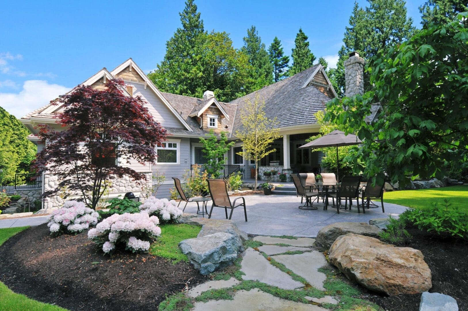 A patio with chairs and tables in the back yard.