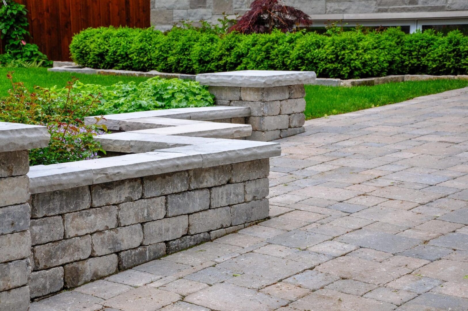 A walkway with steps and stone walls in the middle of a garden.